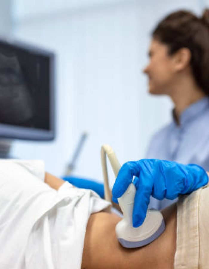 Doctor conducts ultrasound examination of patientv kidneys. Internal organs ultrasound concept. female's lower back diagnosis carried out with the use of an ultrasound